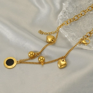 Close-up of 18K gold-plated double-layer bracelet with Roman numeral black enamel charm