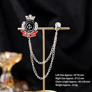Macro shot of vintage emblem brooch with rhinestone studs and silver tassel chains