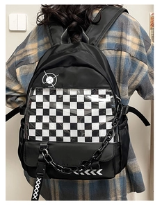 Detailed view of black backpack with checkerboard clear pocket and stylish chain link