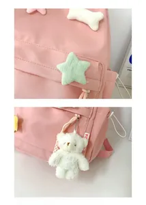 Detail of pink nylon school backpack with plush bear charm and mint star patches