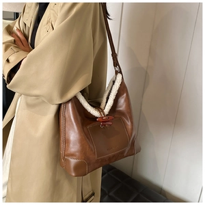 Detail of retro faux fur trim shoulder bag with toggle closure and leather texture