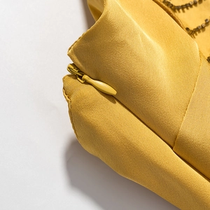 Detail of high-quality yellow evening dress fabric featuring a hidden invisible zipper