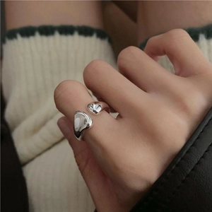 Close-up of liquid-style irregular 925 silver open ring worn by a model in a minimal setting