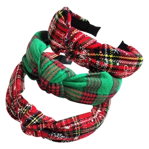 Close-up of three festive plaid knot headbands with red and green snowflake patterns
