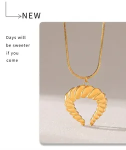 Macro detail van de vergulde croissant hanger aan een slangenketting met vintage boek