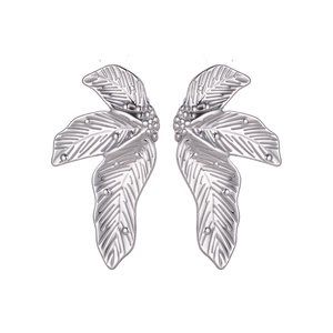 Macro detail of textured silver sunflower leaf steel earrings with bead accents