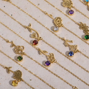 Detailed macro view of vintage gold flower charms with colorful zircon birthstones