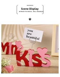 Detail of wooden KISS and Mrs holders with metal coils for photos on a wooden desk