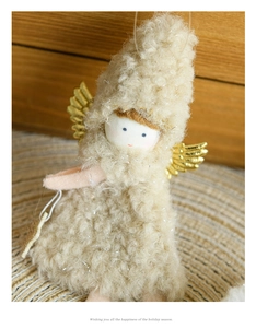 Detail of plush white angel ornament with gold wings on a cozy wooden background