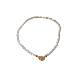 Vintage French pearl necklace with a gold oval zircon-encrusted clasp on white background