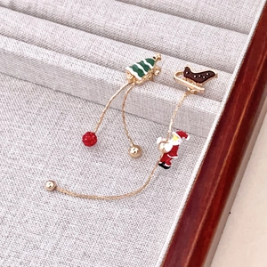 Boucles d'oreilles de Noël asymétriques avec Père Noël et sapin sur présentoir velours
