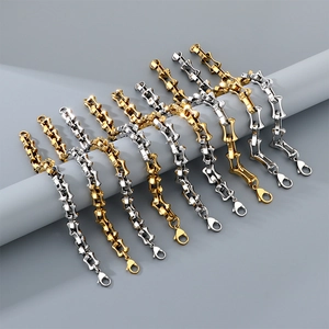 Detail of two-tone stainless steel curb bracelets in gold and silver with lobster clasps