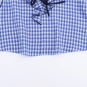 Blau-weiß karierte Bluse mit Rüschendetails und dunkelblauen dekorativen Bindebändern