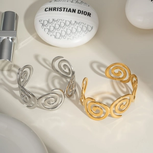 Detail of creative spiral cuff bracelets in gold and silver finish for women