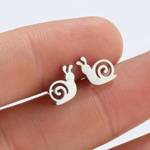 Chic silver snail stud earrings for women shown on hand to demonstrate mini size