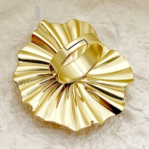 Detailed macro shot of a bold golden pleated flower ring with modern fan-like texture