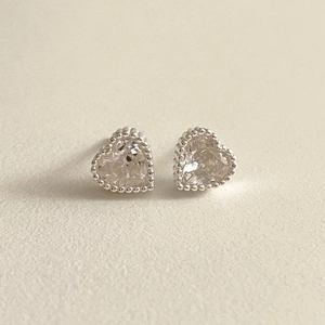 Detail showing heart shaped 925 sterling silver stud earrings with zircon inlay and beaded edge