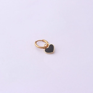 Macro shot of gold hoop earring featuring a black enamel heart pendant detail