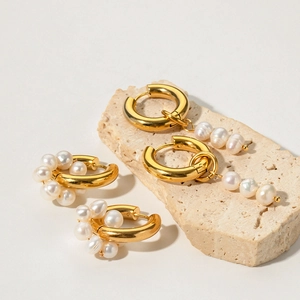Detail of 18K gold-plated asymmetrical earrings with natural freshwater pearl pendants