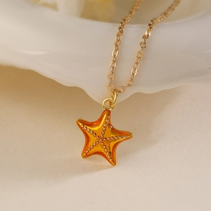 Collier avec pendentif étoile de mer dorée et émail orange sur fond ondulé