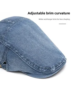 Detail of blue denim newsboy cap with curved foldable brim and reinforced stitching