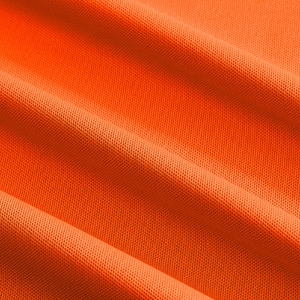 Macro view of bright orange breathable pique knit fabric texture for men's polo shirt