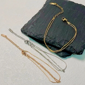 Close-up of double-layer titanium steel snake chain bracelets in gold, silver, and rose gold