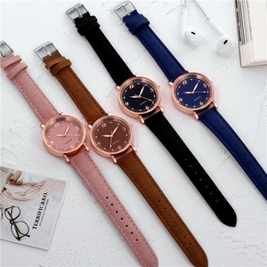 Flat lay of colorful quartz watches with leather straps, rose gold cases and casual props