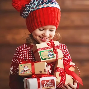 Gros plan d'étiquettes de Noël en papier kraft avec motifs festifs sur coffrets cadeaux