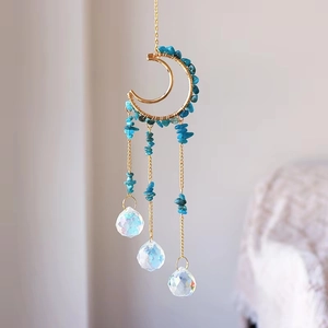 Detailed view of handmade golden moon suncatcher with teal crystals and prism spheres