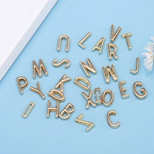 Flat lay of 10mm golden alloy alphabet beads A-Z for DIY jewelry making and bracelets