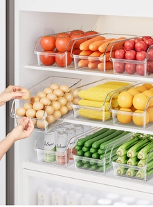 Transparent plastic fridge drawer storage showing organized eggs, vegetables, and beverages