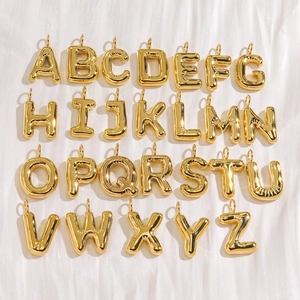 Set of 26 gold balloon-style stainless steel alphabet charms on white silk fabric