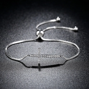 Macro detail of silver sideways cross bracelet with pavé cubic zirconia and slider clasp
