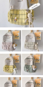 Detail of plaid patterned school backpack with cute plush bunny charms and badges