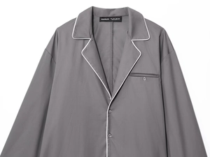 Detail of grey poplin shirt lapel with white contrast piping and chest pocket stitching