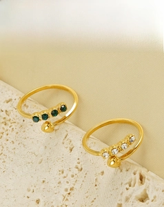 Detail of 18K gold plated stainless steel open rings with green and white zircon stones