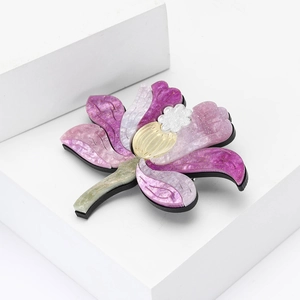 Elegante acryl lotusbroche met roze en paarse glitterblaadjes op een wit voetstuk