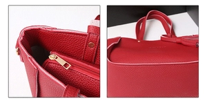 Detail of red litchi texture leather tote with tassel charm and gold zipper pocket