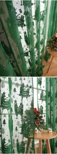 Detail of green lace Christmas curtain featuring reindeer and snowflake patterns