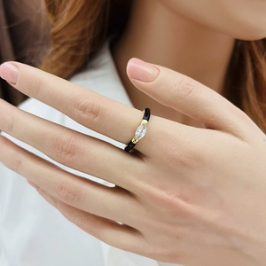 Detail of gold enamel adjustable water drop ring with a marquise gemstone on finger