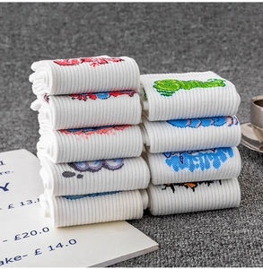 Detail of white cotton athletic socks featuring colorful graffiti patterns and ribbed texture