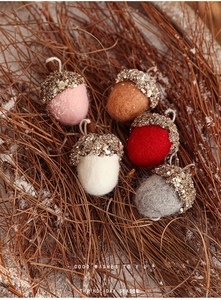 Detail of five handmade felt acorn ornaments with sequins for Christmas tree decor