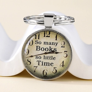 Detail of vintage pocket watch keychain with 'So many Books so little Time' quote
