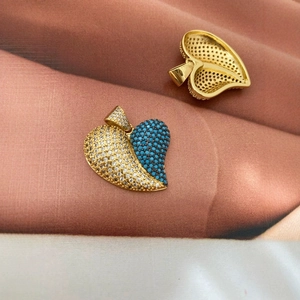 Pendentif coeur doré serti de zircons bleus et blancs sur un support en tissu doux