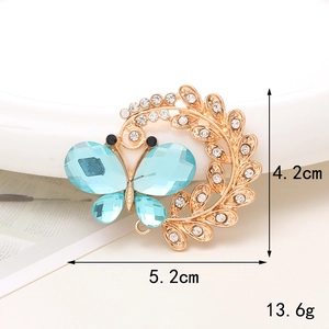 Dettaglio con dimensioni 4,2x5,2cm e peso 13,6g della spilla a farfalla blu e oro