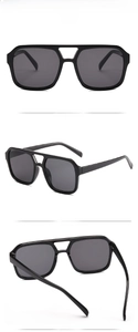 Detail view of black square double-bridge sunglasses with dark grey polarized lenses