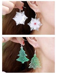 Détail de boucles d'oreilles en résine DIY en forme de flocon blanc et sapin vert pailleté