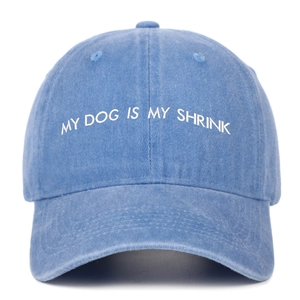 Detail of white My Dog Is My Shrink embroidery on washed blue cotton baseball cap