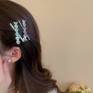 Détail de deux barrettes à cheveux en cristal portées sur le côté pour un style élégant